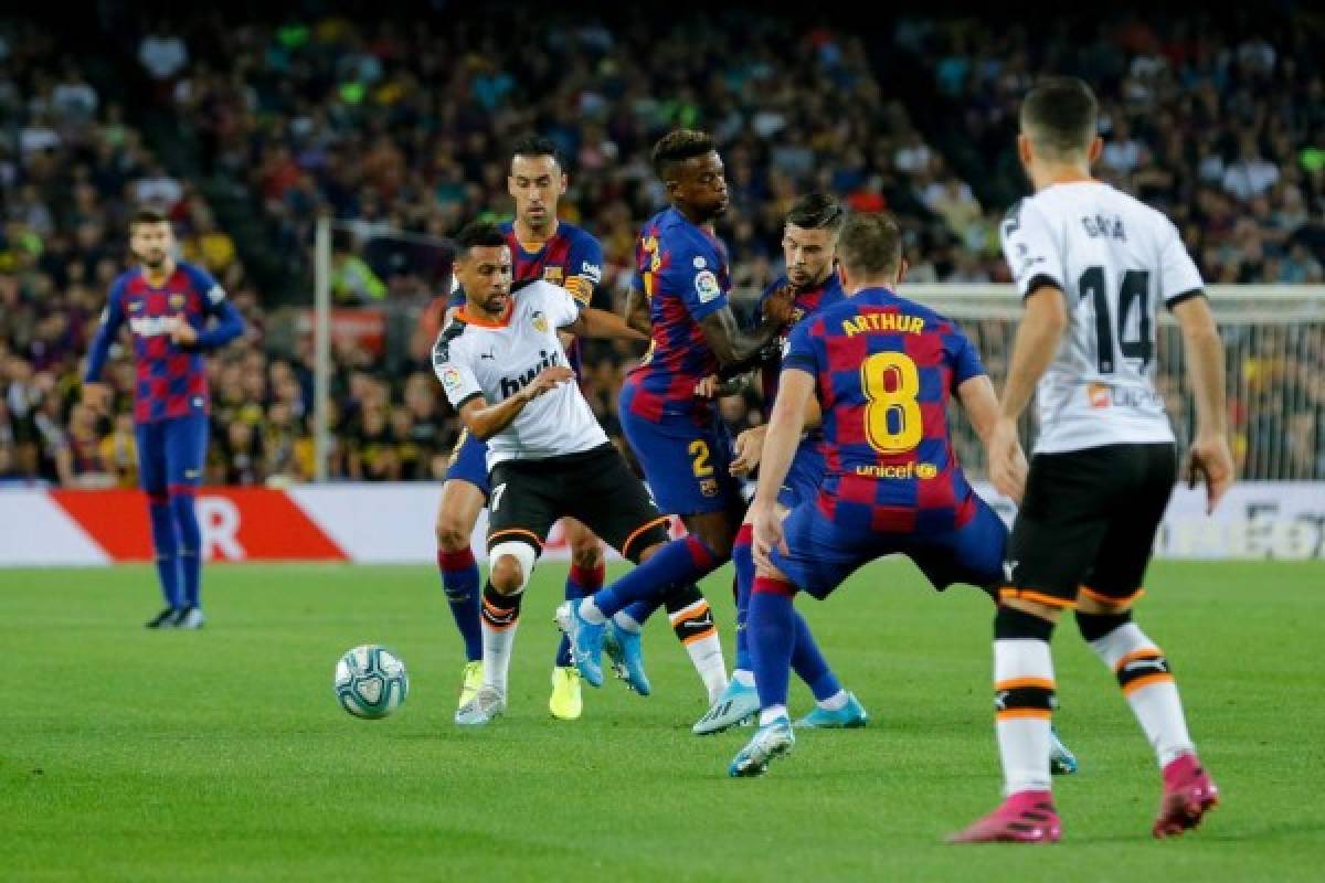 Valencia's French midfielder Francis Coquelin (C) vies with Barcelona's Spanish midfielder Sergio Busquets, Barcelona's Portuguese defender Nelson Semedo and Barcelona's Brazilian midfielder Arthur during the Spanish league football match FC Barcelona against Valencia CF at the Camp Nou stadium in Barcelona on September 14, 2019. (Photo by Pau Barrena / AFP)