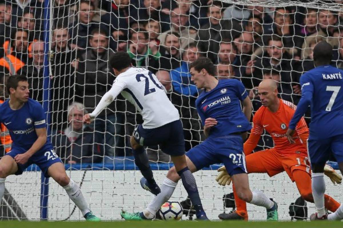 Tottenham Hotspur's English midfielder Dele Alli (C) shoots to score their third goal during the English Premier League football match between Chelsea and Tottenham Hotspur at Stamford Bridge in London on April 1, 2018. / AFP PHOTO / Daniel LEAL-OLIVAS / RESTRICTED TO EDITORIAL USE. No use with unauthorized audio, video, data, fixture lists, club/league logos or 'live' services. Online in-match use limited to 75 images, no video emulation. No use in betting, games or single club/league/player publications. /