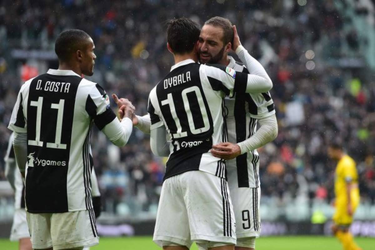 Juventus' forward from Argentina Paulo Dybala (C) celebrates with teammates Juventus' forward from Argentina Gonzalo Higuain (R) and Juventus' forward from Brazil Douglas Costa after scoring during the Italian Serie A football match Juventus vs Udinese on March 11, 2018 at the Juventus stadium in Turin. / AFP PHOTO / Miguel MEDINA