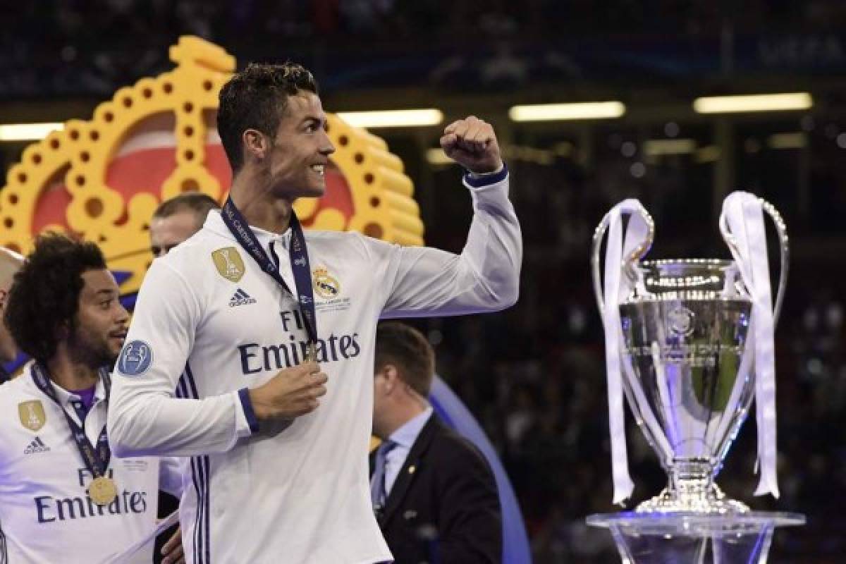 Real Madrid's Portuguese striker Cristiano Ronaldo celebrates next to the trophy after Real Madrid won the UEFA Champions League final football match between Juventus and Real Madrid at The Principality Stadium in Cardiff, south Wales, on June 3, 2017. / AFP PHOTO / JAVIER SORIANO