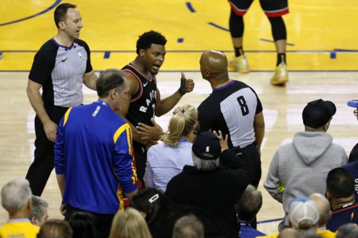 OAKLAND, CALIFORNIA - JUNE 05: Kyle Lowry #7 of the Toronto Raptors complains to referee Marc Davis #8 after being pushed by Warriors minority investor Mark Stevens (blue shirt, seated) in the second half against the Golden State Warriors during Game Three of the 2019 NBA Finals at ORACLE Arena on June 05, 2019 in Oakland, California. According to to the Warriors, Stevens will not be in attendance for the remainder of the NBA Finals as they look further into the incident. NOTE TO USER: User expressly acknowledges and agrees that, by downloading and or using this photograph, User is consenting to the terms and conditions of the Getty Images License Agreement. Lachlan Cunningham/Getty Images/AFP