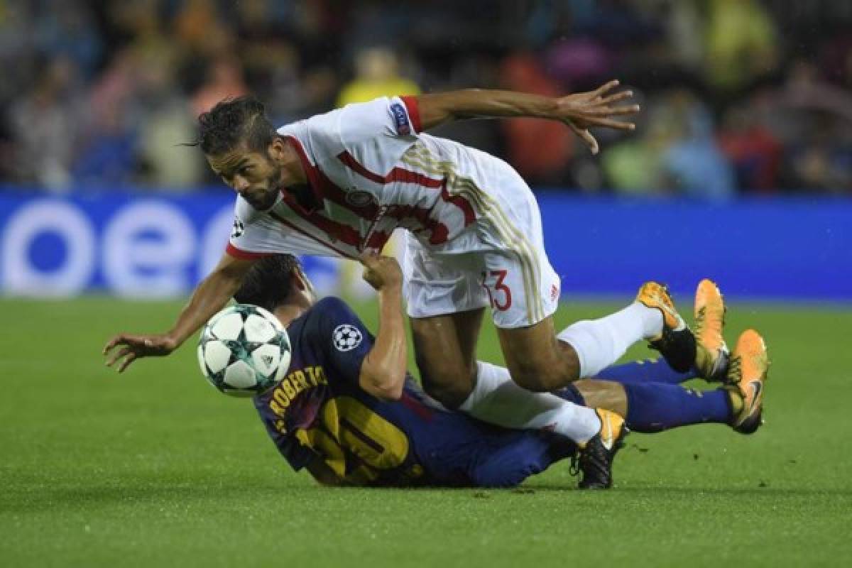 Olympiacos' Moroccan midfielder Mehdi Carcela-Gonzalez (top) vies with Barcelona's Spanish midfielder Sergi Roberto during the UEFA Champions League group D football match FC Barcelona vs Olympiacos FC at the Camp Nou stadium in Barcelona on Ocotber 18, 2017. / AFP PHOTO / LLUIS GENE