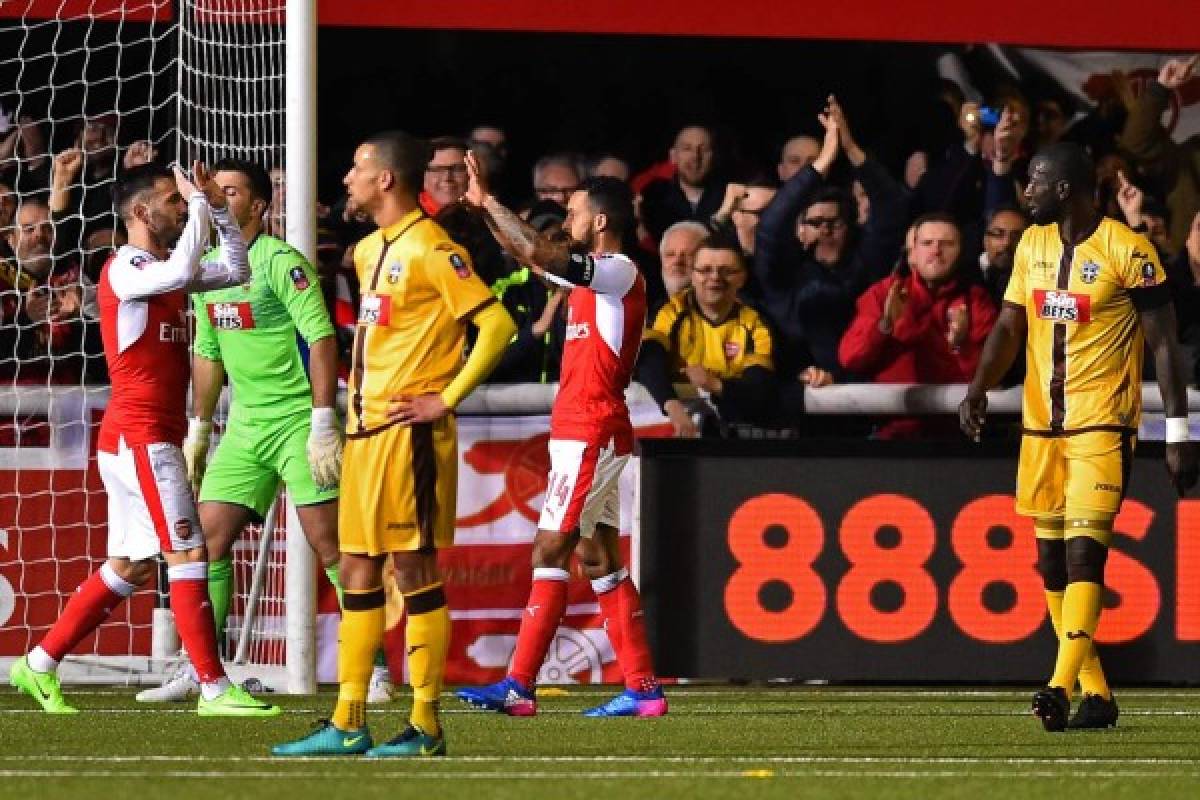 Arsenal's English midfielder Theo Walcott (2nd R) celebrates with teammates after scoring their second goal, his 100th goal for Arsenal, during the English FA Cup fifth round football match between Sutton United and Arsenal at the Borough Sports Ground, Gander Green Lane in south London on February 20, 2017. / AFP PHOTO / Glyn KIRK / RESTRICTED TO EDITORIAL USE. No use with unauthorized audio, video, data, fixture lists, club/league logos or 'live' services. Online in-match use limited to 75 images, no video emulation. No use in betting, games or single club/league/player publications. /