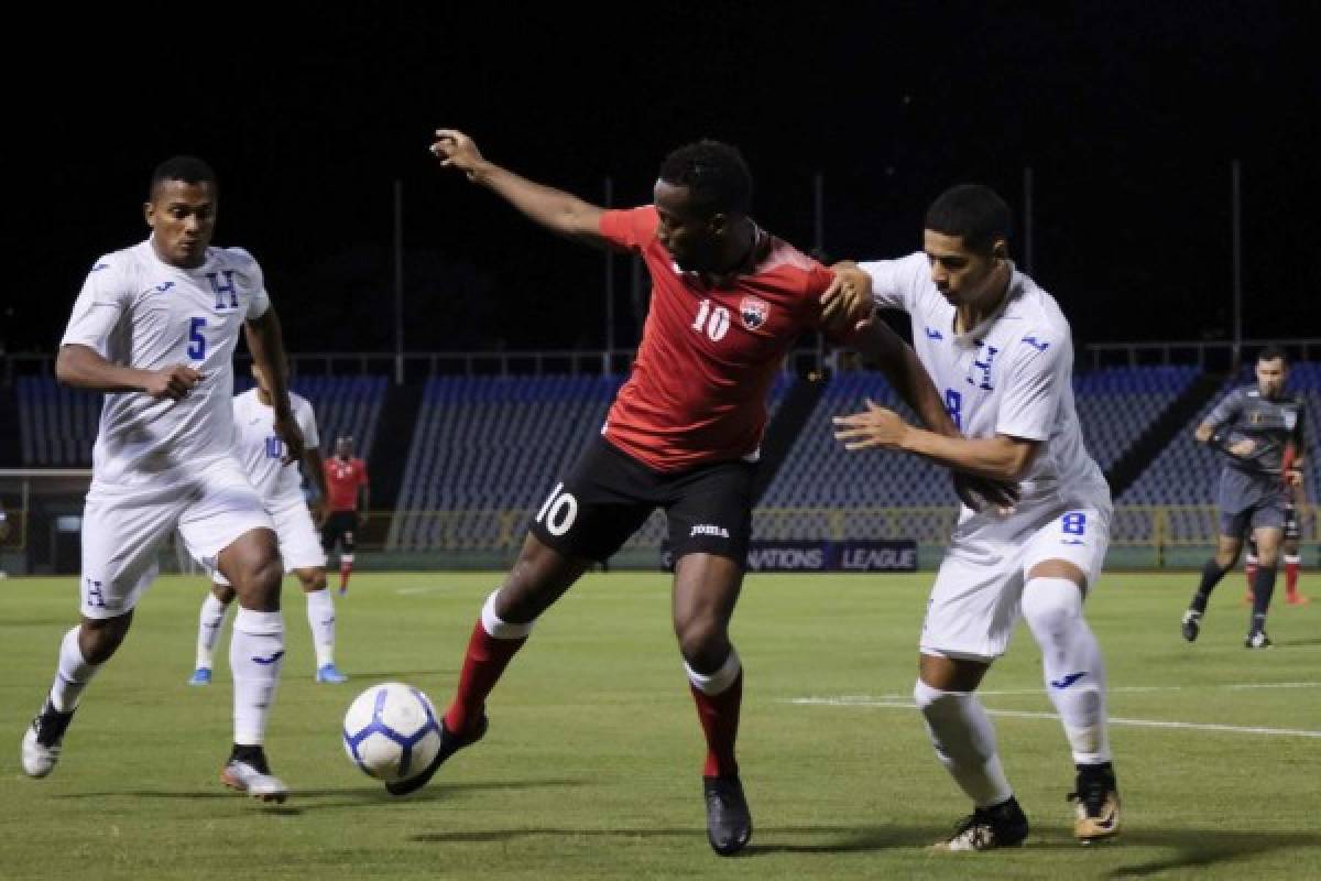In this handout photo released by CONCACAF Kevin Molino of Trinidad and Tobago (C) vies for the ball with Carlos Pineda of Honduras during their Concacaf Nations League A tournament match at Hasely Crawford Stadium in Port of Spain, Trinidad and Tobago on October 10, 2019. (Photo by HO / CONCACAF / AFP) / RESTRICTED TO EDITORIAL USE - MANDATORY CREDIT 'AFP PHOTO /CONCACAF' - NO MARKETING - NO ADVERTISING CAMPAIGNS - DISTRIBUTED AS A SERVICE TO CLIENTS