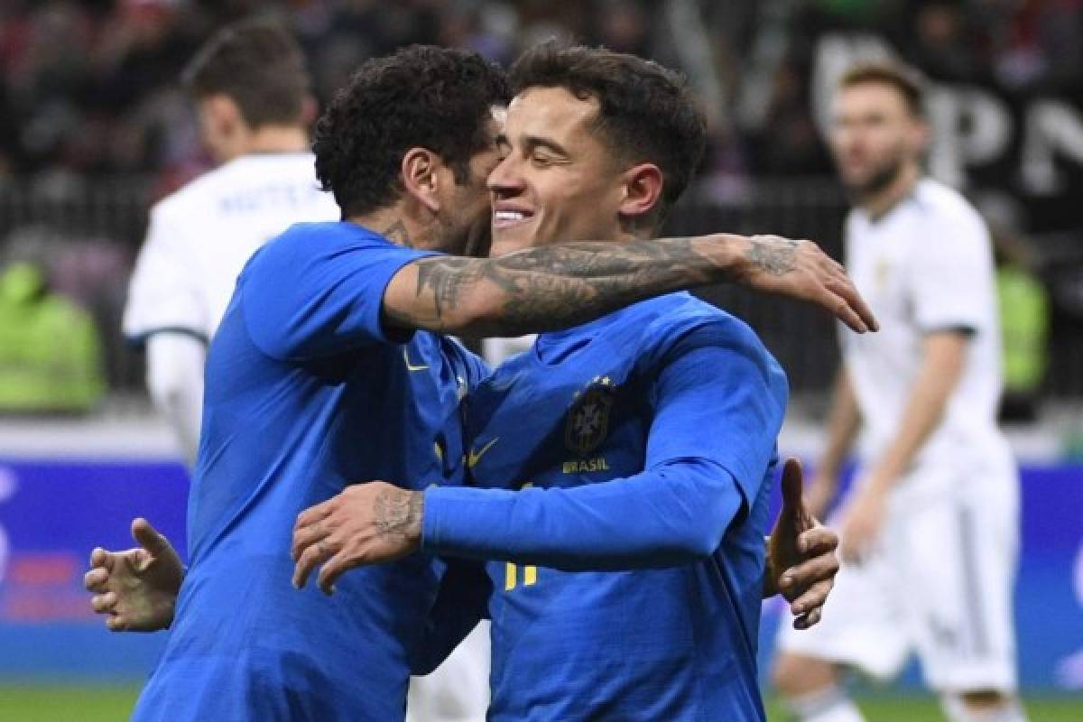 Brazil's midfielder Philippe Coutinho (R) celebrates with Brazil's defender Dani Alves after scoring the team's second goal from a penalty spot during an international friendly football match between Russia and Brazil at the Luzhniki stadium in Moscow on March 23, 2018. / AFP PHOTO / Alexander NEMENOV