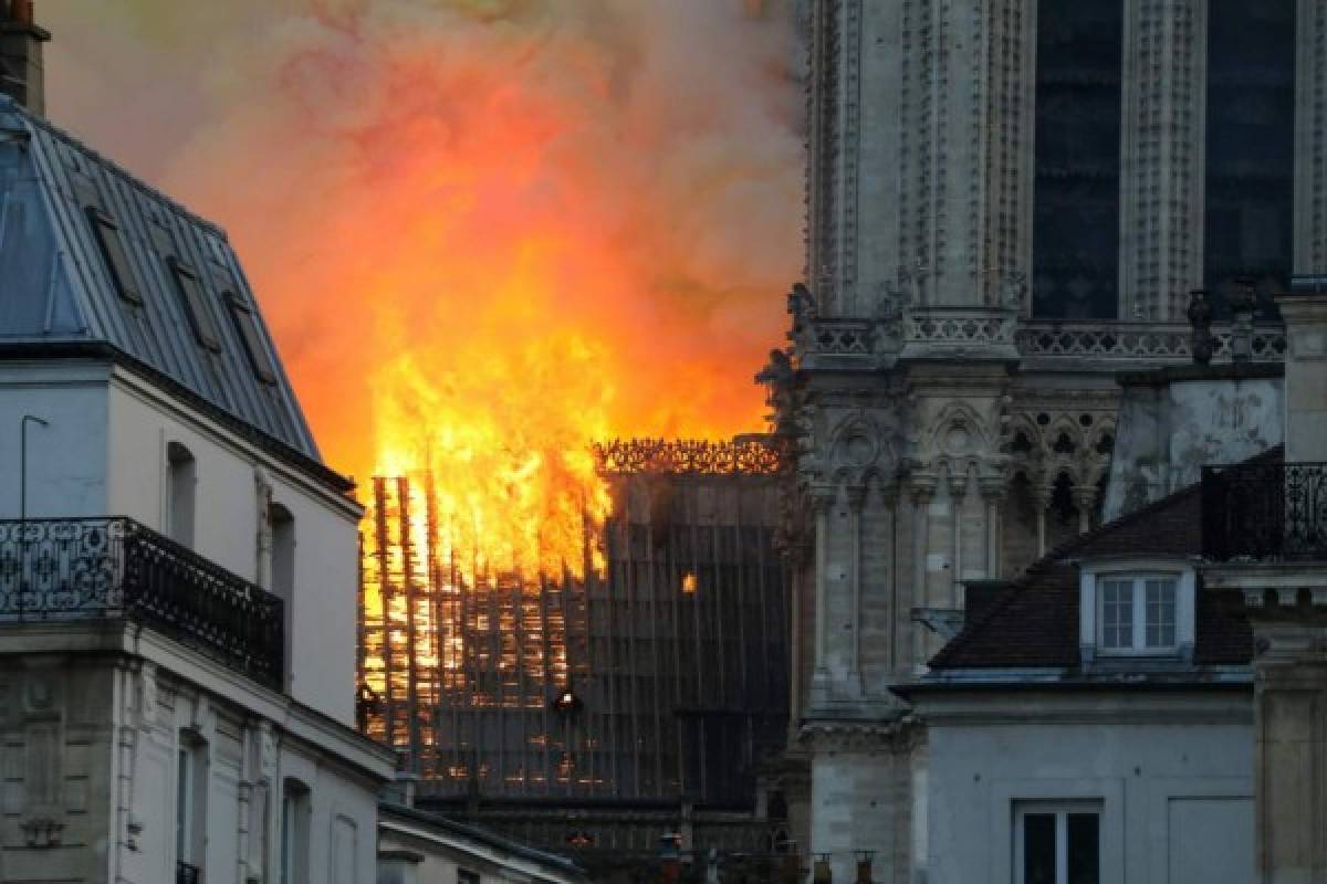 Smoke and flames rise during a fire at the landmark Notre-Dame Cathedral in central Paris on April 15, 2019, potentially involving renovation works being carried out at the site, the fire service said. - A major fire broke out at the landmark Notre-Dame Cathedral in central Paris sending flames and huge clouds of grey smoke billowing into the sky, the fire service said. The flames and smoke plumed from the spire and roof of the gothic cathedral, visited by millions of people a year, where renovations are currently underway. (Photo by LUDOVIC MARIN / AFP)
