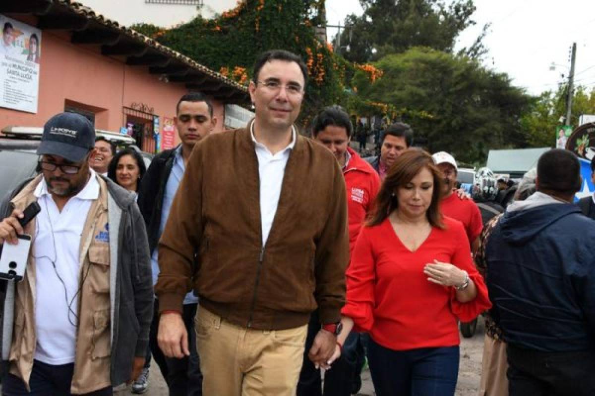 The presidential candidate of the opposition Liberal Party Luis Zelaya (C), accompained by his wife Ana Lucia, leaves after casting his vote at polling station in Santa Lucia municipality, 11 kilometres east of Tegucigalpa, during the general election on November 26, 2017.Honduras' six million voters are to cast ballots in a controversial election Sunday in which President Juan Orlando Hernandez is seeking a second mandate despite a constitutional one-term limit. This small country is at the heart of Central America's 'triangle of death,' an area plagued by gangs and poverty. / AFP PHOTO / ORLANDO SIERRA