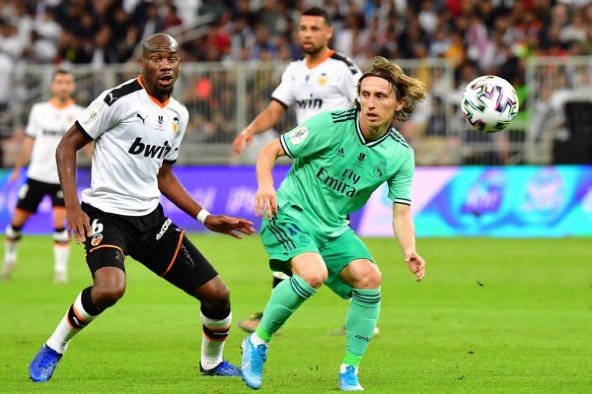 Valencia's Central African Republic-French midfielder Geoffrey Kondogbia (L) vies for the ball with Real Madrid's Croatian midfielder Luka Modric during the Spanish Super Cup semi final between Valencia and Real Madrid on January 8, 2020, at the King Abdullah Sport City in the Saudi Arabian port city of Jeddah. (Photo by GIUSEPPE CACACE / AFP)