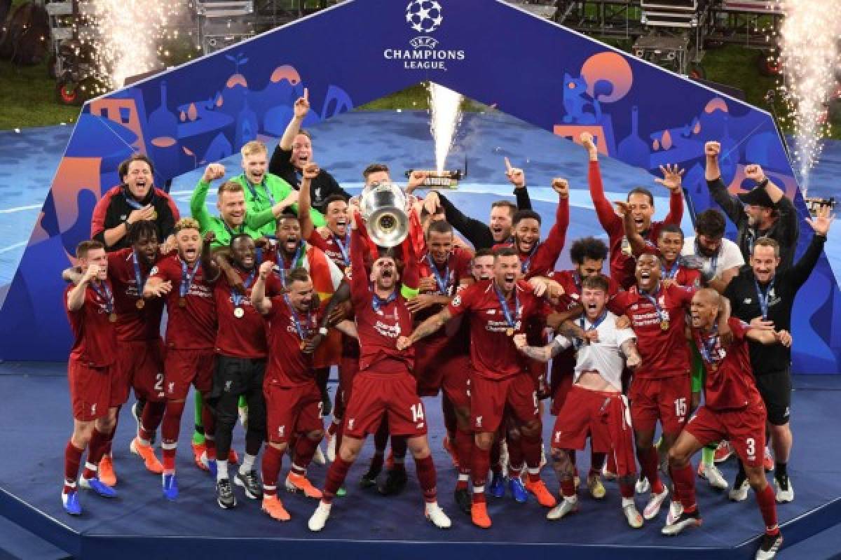 Liverpool's players celebrate with the trophy after winning the UEFA Champions League final football match between Liverpool and Tottenham Hotspur at the Wanda Metropolitan Stadium in Madrid on June 1, 2019. (Photo by ANTONIN THUILLIER / AFP)
