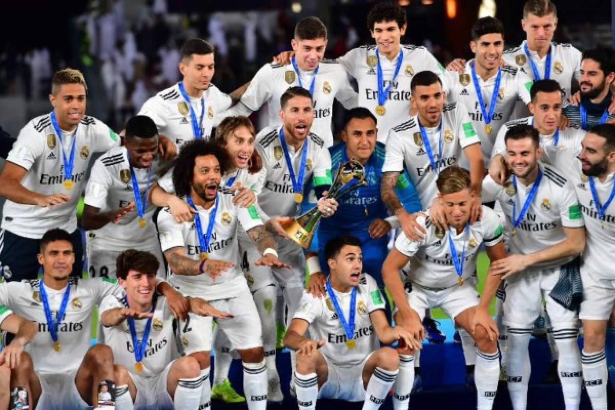 Real Madrid's players celebrate with the trophy after winning the FIFA Club World Cup final football match Spain's Real Madrid vs Abu Dhabi's Al Ain at the Zayed Sports City Stadium in Abu Dhabi, the capital of the United Arab Emirates, on December 22, 2018. (Photo by Giuseppe CACACE / AFP)