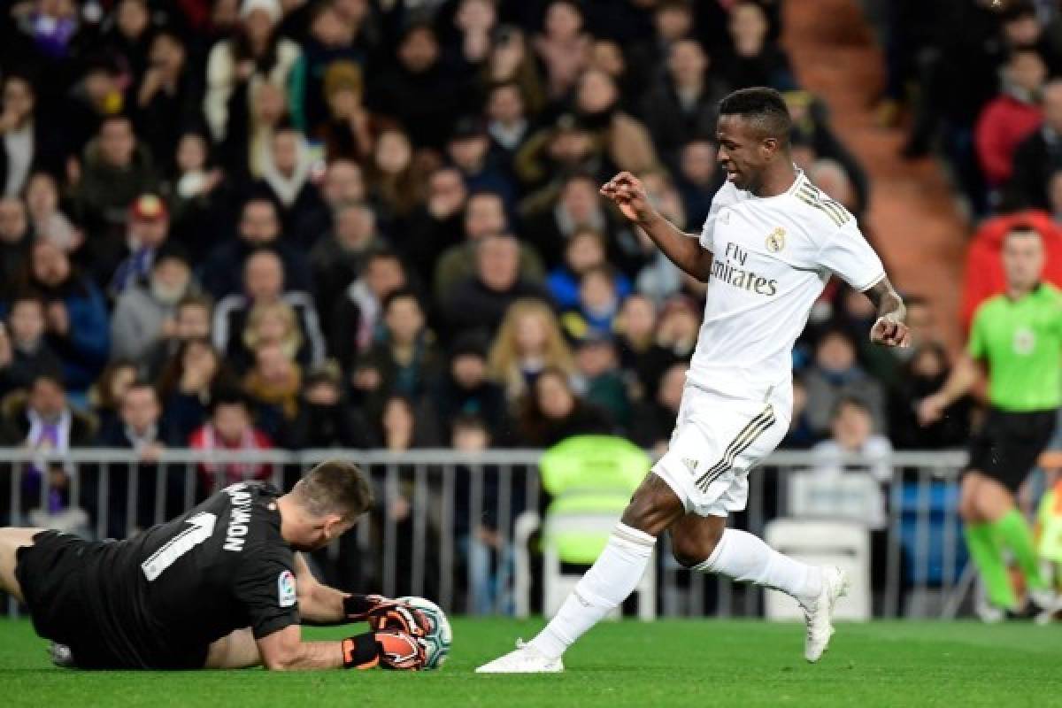 Real Madrid's Brazilian forward Vinicius Junior (R) challenges Athletic Bilbao's Spanish goalkeeper Unai Simon during the Spanish league football match Real Madrid CF against Athletic Club Bilbao at the Santiago Bernabeu stadium in Madrid on December 22, 2019. (Photo by JAVIER SORIANO / AFP)