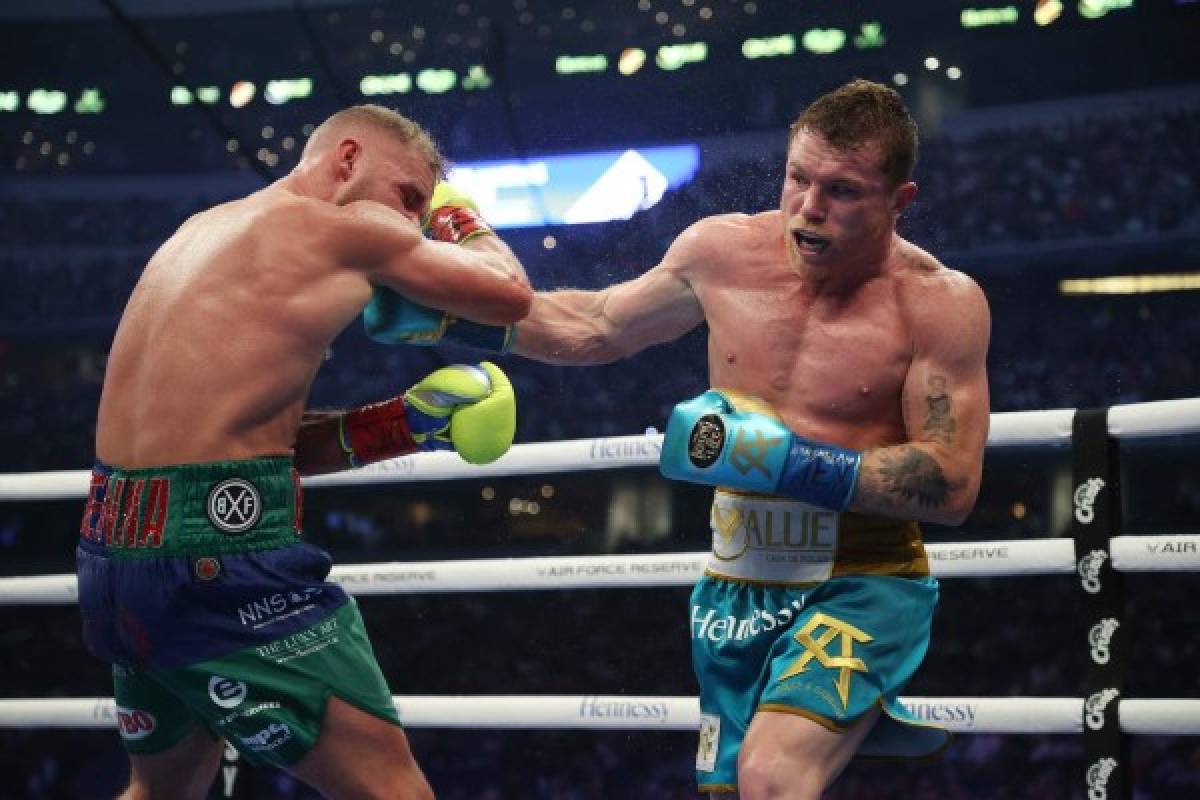 ARLINGTON, TEXAS - MAY 08: Canelo Alvarez punches Billy Joe Saunders during their fight for Alvarez's WBC and WBA super middleweight titles and Saunders' WBO super middleweight title at AT&T Stadium on May 08, 2021 in Arlington, Texas. Al Bello/Getty Images/AFP (Photo by AL BELLO / GETTY IMAGES NORTH AMERICA / Getty Images via AFP)