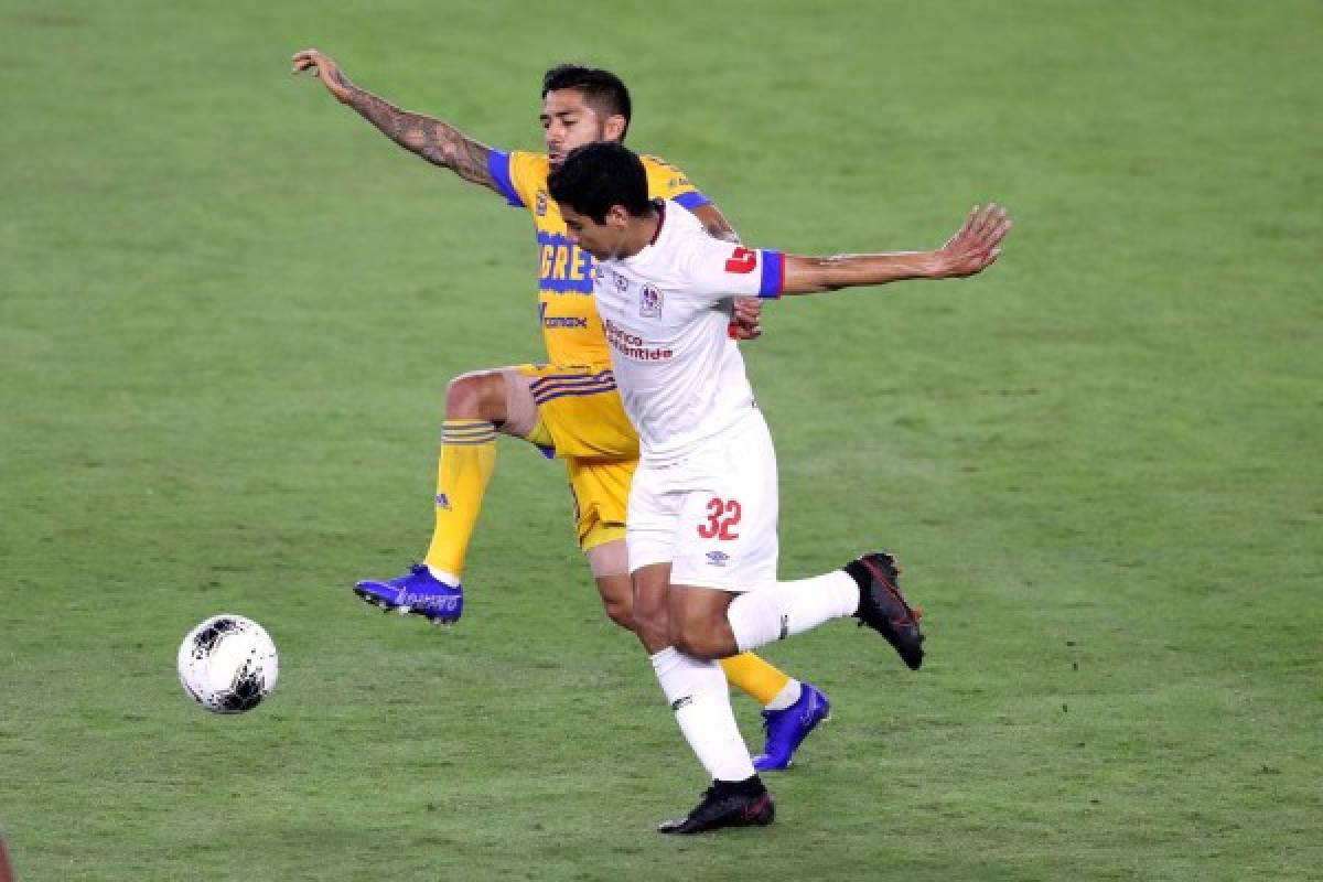 ORLANDO, FL - DECEMBER 19: Javier Aquino #20 of Tigres UANL and Carlos Pineda #32 of CD Olimpia compete for the ball during the CONCACAF Champions League semifinal game at Exploria Stadium on December 19, 2020 in Orlando, Florida. Alex Menendez/Getty Images/AFP== FOR NEWSPAPERS, INTERNET, TELCOS & TELEVISION USE ONLY ==