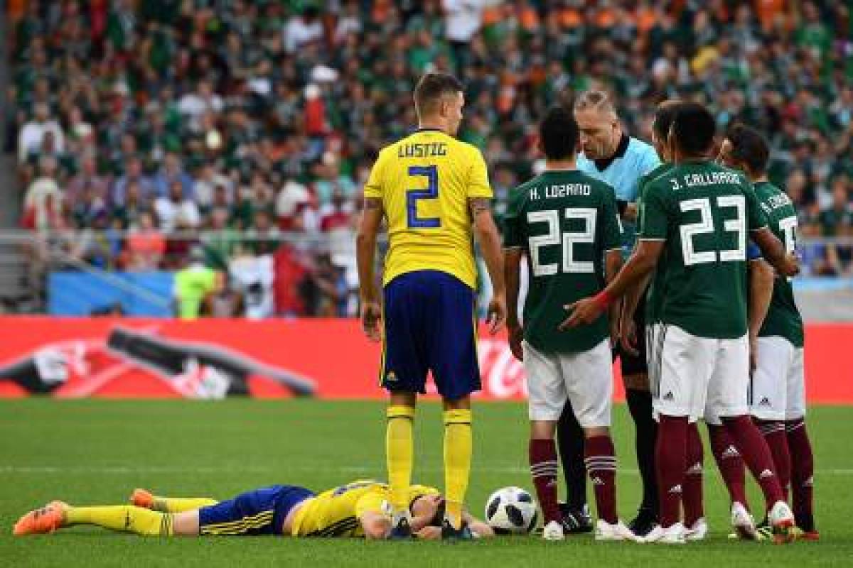 Argentine referee Nestor Pitana presents Mexico's defender Jesus Gallardo with a yellow card during the Russia 2018 World Cup Group F football match between Mexico and Sweden at the Ekaterinburg Arena in Ekaterinburg on June 27, 2018. / AFP PHOTO / Anne-Christine POUJOULAT / RESTRICTED TO EDITORIAL USE - NO MOBILE PUSH ALERTS/DOWNLOADS