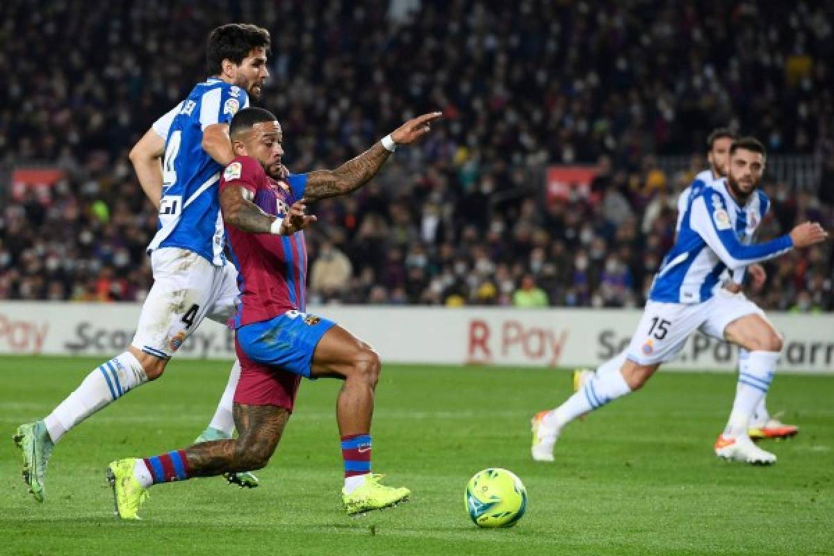 Espanyol's Uruguayan defender Leandro Cabrera (L) fights for the ball with Barcelona's Dutch forward Memphis Depay during the Spanish league football match between FC Barcelona and RCD Espanyol, at the Camp Nou stadium in Barcelona on November 20, 2021. (Photo by Josep LAGO / AFP)