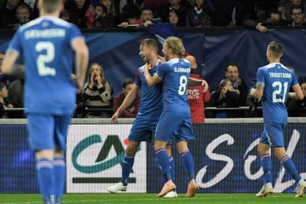 Iceland players celebrate after scoring a goal during the friendly football match between France and Iceland at the Roudourou Stadium in Guingamp, western France on October 11, 2018. (Photo by LOIC VENANCE / AFP)