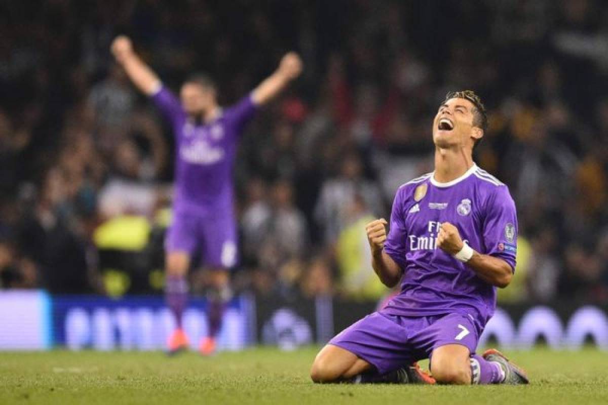 Real Madrid's Portuguese striker Cristiano Ronaldo falls to his knees as he celebrates their victory on the final whistle of the UEFA Champions League final football match between Juventus and Real Madrid at The Principality Stadium in Cardiff, south Wales, on June 3, 2017.Real Madrid beat Juventus 4-1 to win Champions League. / AFP PHOTO / Glyn KIRK