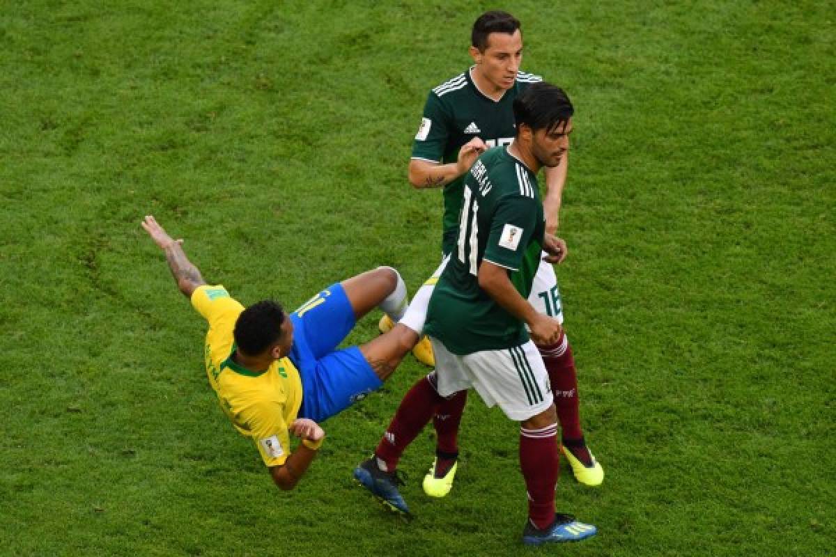 Brazil's forward Neymar (L) falls after a challenge from Mexico's midfielder Andres Guardado (C) and Mexico's forward Carlos Vela during the Russia 2018 World Cup round of 16 football match between Brazil and Mexico at the Samara Arena in Samara on July 2, 2018. / AFP PHOTO / SAEED KHAN / RESTRICTED TO EDITORIAL USE - NO MOBILE PUSH ALERTS/DOWNLOADS