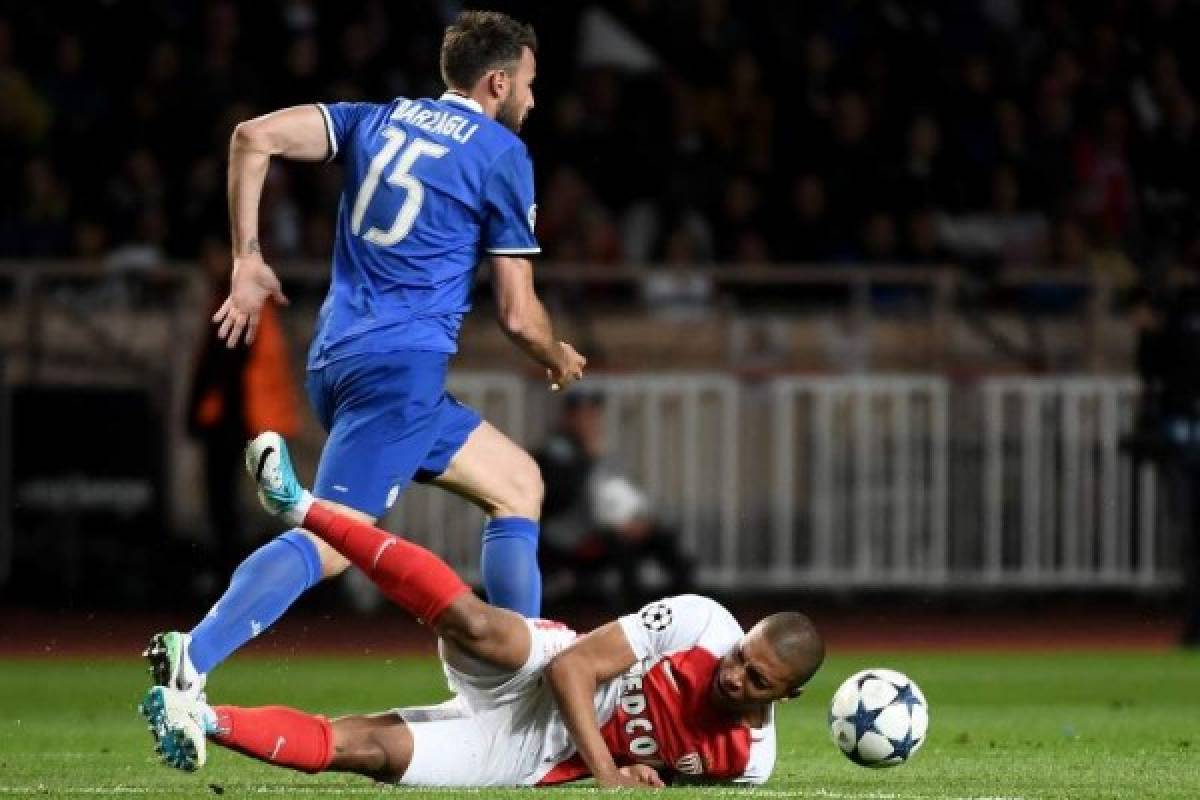 Juventus' defender from Italy Andrea Barzagli (top) fights for the ball against Monaco's French forward Kylian Mbappe during the UEFA Champions League semi-final first leg football match Monaco vs Juventus at the Stade Louis II stadium in Monaco on May 3, 2017. / AFP PHOTO / Anne-Christine POUJOULAT