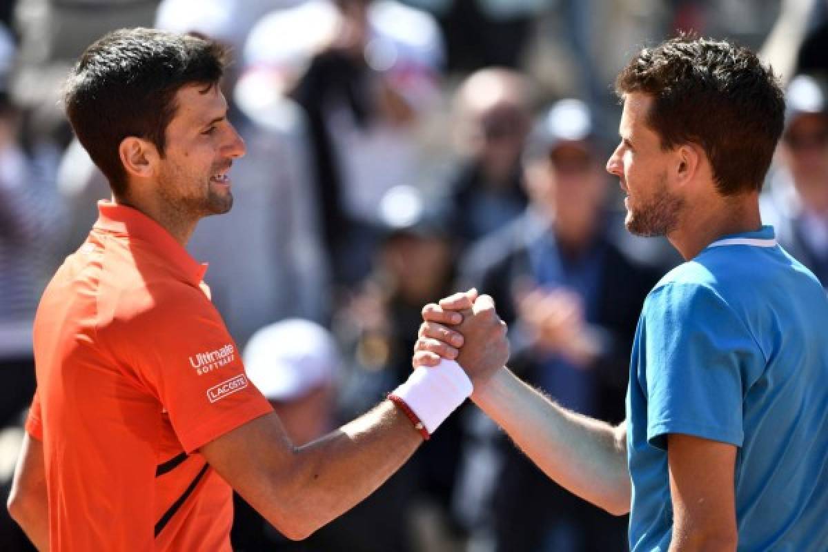 Austria's Dominic Thiem (R) and Serbia's Novak Djokovic shake hands at the end of their men's singles semi-final match on day fourteen of The Roland Garros 2019 French Open tennis tournament in Paris on June 8, 2019. (Photo by Philippe LOPEZ / AFP)