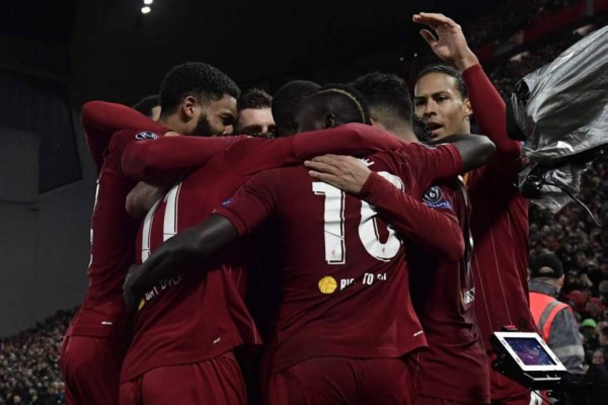 Liverpool's Brazilian midfielder Roberto Firmino celebrates with teammates after celebrates scoring his team's second goal during the UEFA Champions league Round of 16 second leg football match between Liverpool and Atletico Madrid at Anfield in Liverpool, north west England on March 11, 2020. (Photo by JAVIER SORIANO / AFP)