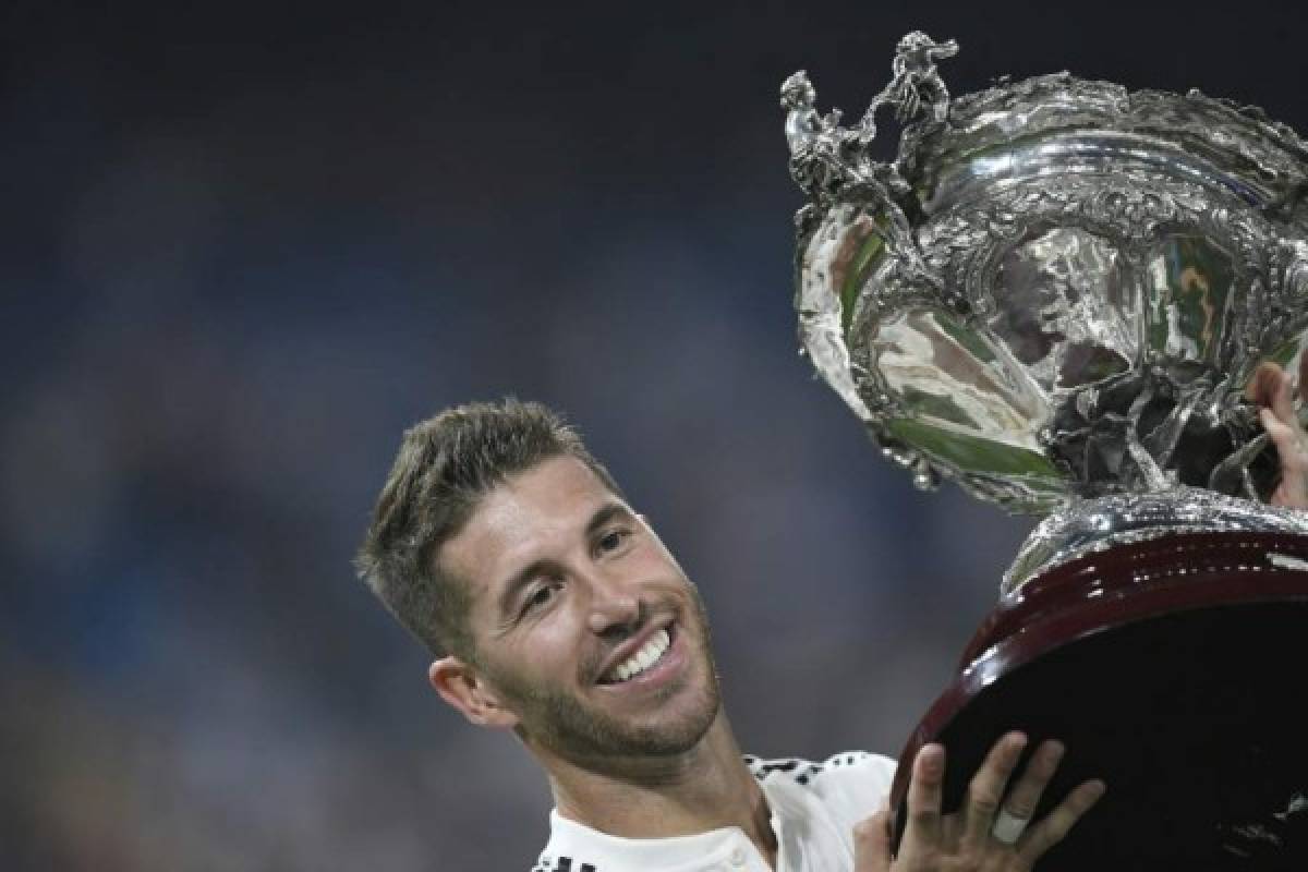 Real Madrid's Spanish defender Sergio Ramos celebrates with the trophy after the Santiago Bernabeu Trophy football match between Real Madrid and AC Milan in Madrid on August 11, 2018. / AFP PHOTO / GABRIEL BOUYS