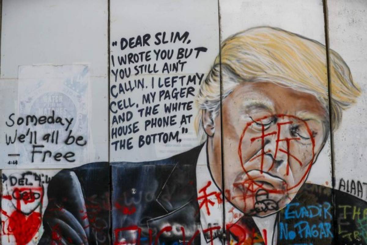 A picture shows the vandalised mural painting of US President Donald Trump on Israel's controversial separation barrier in the West Bank city of Bethlehem on January 3, 2020. - The Pentagon said US President Donald Trump had ordered Qasem Soleimani's 'killing' after a pro-Iran mob this week laid siege to the US embassy in the Iraqi capital. Iran's supreme leader Ayatollah Ali Khamenei swiftly promised 'severe revenge' for Soleimani's death, the biggest escalation yet in a feared proxy war between Iran and the US on Iraqi soil. (Photo by AHMAD GHARABLI / AFP)