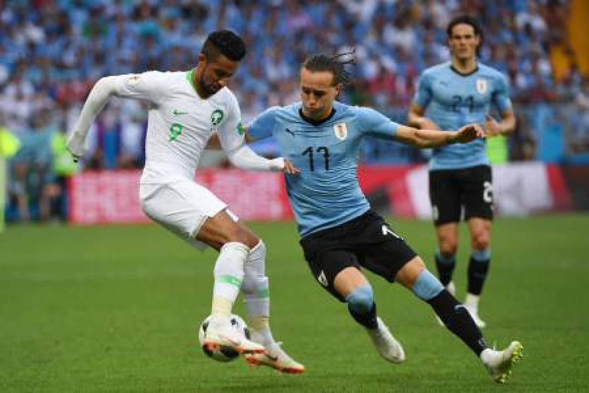 Saudi Arabia's midfielder Hatan Babhir (L) vies with Uruguay's defender Diego Laxalt during the Russia 2018 World Cup Group A football match between Uruguay and Saudi Arabia at the Rostov Arena in Rostov-On-Don on June 20, 2018. / AFP PHOTO / Khaled DESOUKI / RESTRICTED TO EDITORIAL USE - NO MOBILE PUSH ALERTS/DOWNLOADS