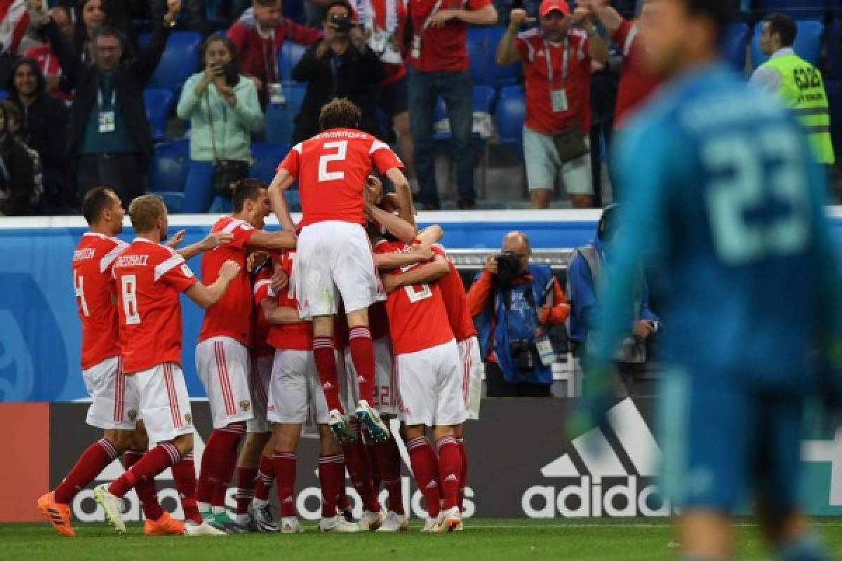 TOPSHOT - Russia's players celebrate after Egypt's defender Ahmed Fathi own goal during the Russia 2018 World Cup Group A football match between Russia and Egypt at the Saint Petersburg Stadium in Saint Petersburg on June 19, 2018. / AFP PHOTO / Giuseppe CACACE / RESTRICTED TO EDITORIAL USE - NO MOBILE PUSH ALERTS/DOWNLOADS