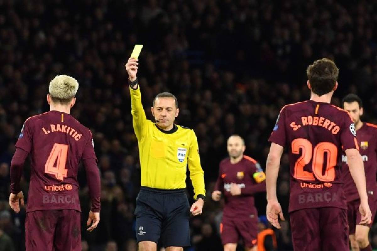 Referee Cuneyt Cakur (2L) gives Barcelona's Croatian midfielder Ivan Rakitic (L) a yellow card during the first leg of the UEFA Champions League round of 16 football match between Chelsea and Barcelona at Stamford Bridge stadium in London on February 20, 2018. / AFP PHOTO / Ben STANSALL
