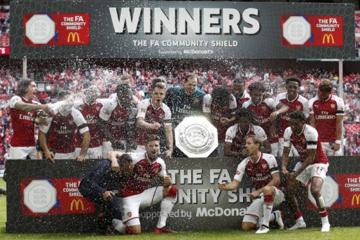 Arsenal players hold the Community Shield trophy as they celebrate victory after the English FA Community Shield football match between Arsenal and Chelsea at Wembley Stadium in north London on August 6, 2017.Arsenal won 4-1 on penalties after the game ended 1-1. / AFP PHOTO / Ian KINGTON / NOT FOR MARKETING OR ADVERTISING USE / RESTRICTED TO EDITORIAL USE