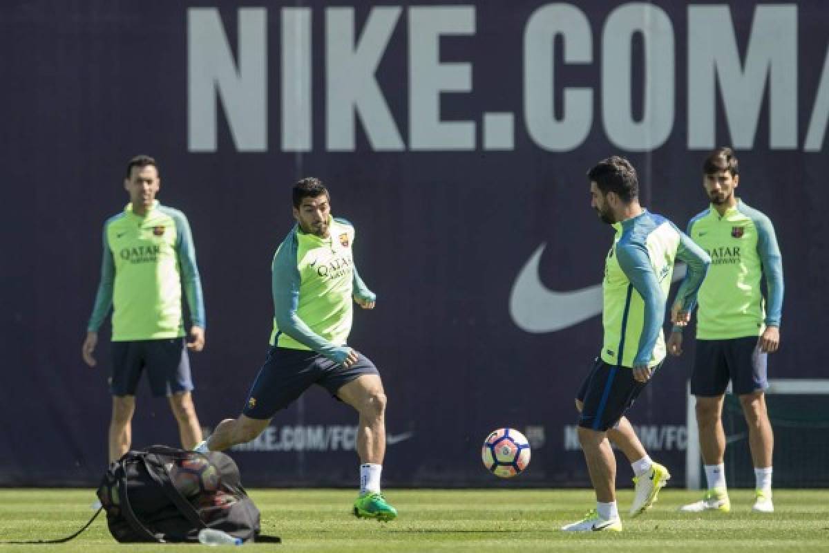 Barcelona's Uruguayan forward Luis Suarez (L) eyes a ball with Barcelona's Turkish midfielder Arda Turan during a training session at the Sports Center FC Barcelona Joan Gamper in Sant Joan Despi, near Barcelona on April 22, 2017 on the eve of their Spanish League Clasico football match Real Madrid vs FC Barcelona. / AFP PHOTO / Josep LAGO