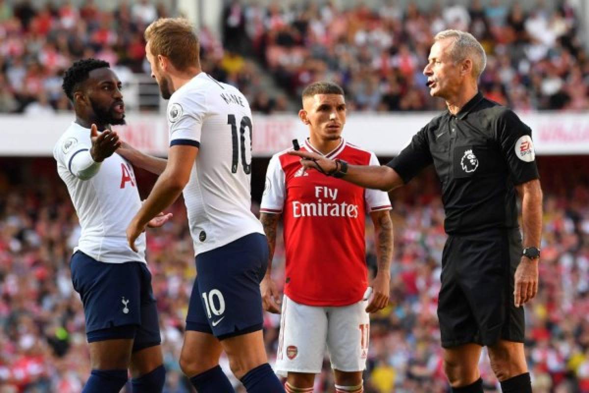 Tottenham Hotspur's English defender Danny Rose (L) is spoken to by Tottenham Hotspur's English striker Harry Kane (2nd L) and English referee Martin Atkinson (R) looks on during the English Premier League football match between Arsenal and Tottenham Hotspur at the Emirates Stadium in London on September 1, 2019. (Photo by Ben STANSALL / AFP) / RESTRICTED TO EDITORIAL USE. No use with unauthorized audio, video, data, fixture lists, club/league logos or 'live' services. Online in-match use limited to 120 images. An additional 40 images may be used in extra time. No video emulation. Social media in-match use limited to 120 images. An additional 40 images may be used in extra time. No use in betting publications, games or single club/league/player publications. /
