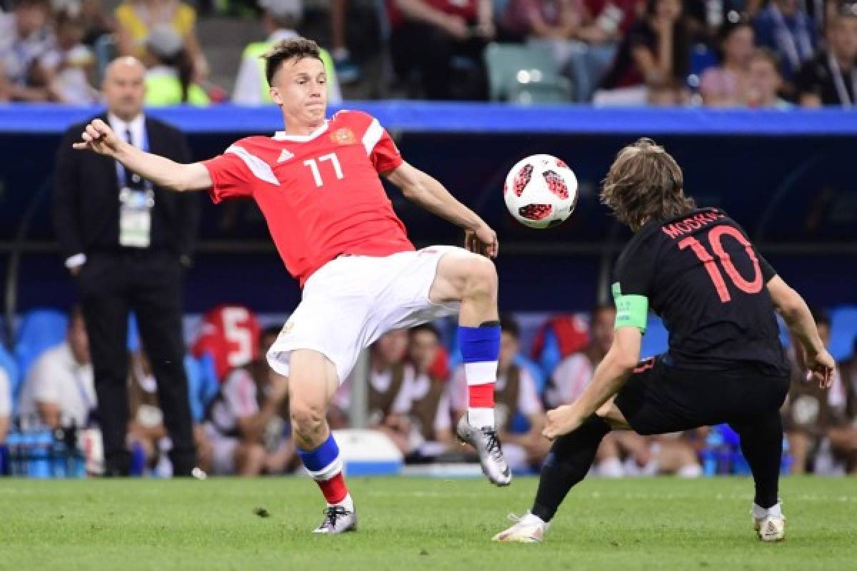 Russia's midfielder Aleksandr Golovin (L) challenges Croatia's midfielder Luka Modric during the Russia 2018 World Cup quarter-final football match between Russia and Croatia at the Fisht Stadium in Sochi on July 7, 2018. / AFP PHOTO / PIERRE-PHILIPPE MARCOU / RESTRICTED TO EDITORIAL USE - NO MOBILE PUSH ALERTS/DOWNLOADS