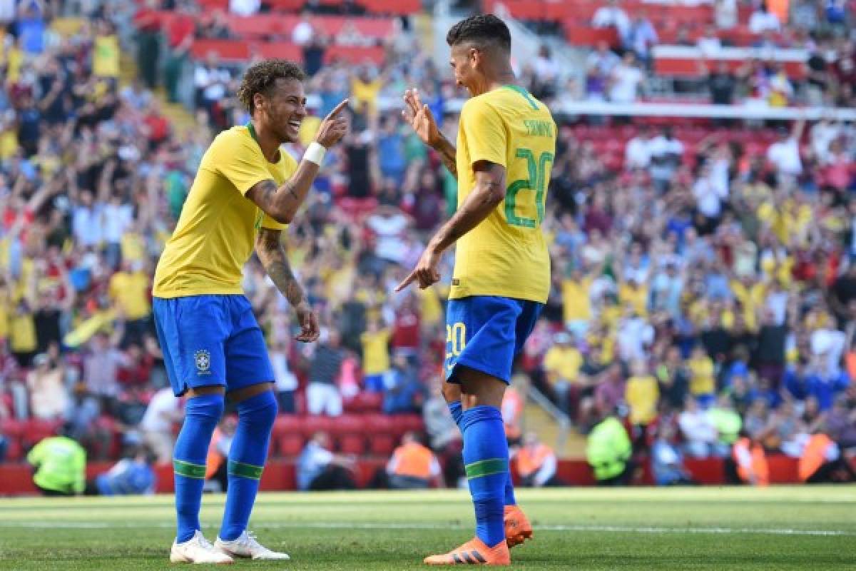 Brazil's striker Roberto Firmino (R) celebrates with Brazil's striker Neymar after scoring their second goal during the International friendly football match between Brazil and Croatia at Anfield in Liverpool on June 3, 2018.Brazil won the game 2-0. / AFP PHOTO / Oli SCARFF