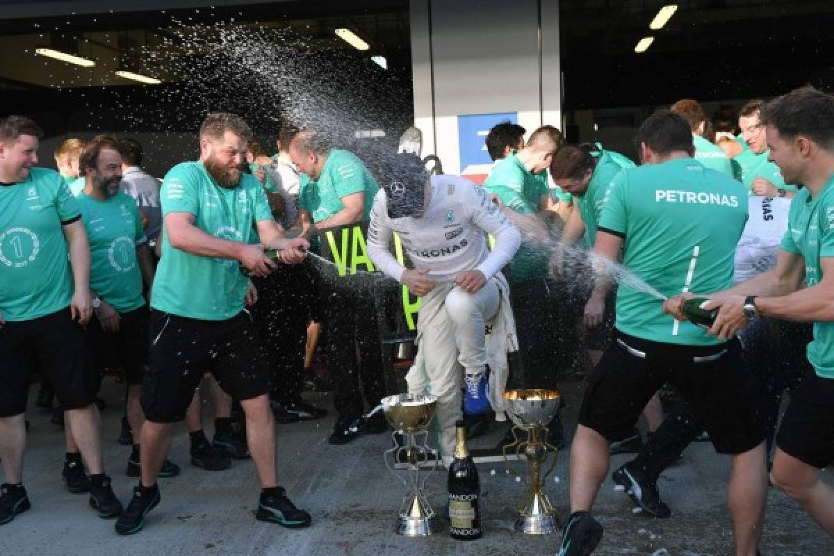 Mercedes' Finnish driver Valtteri Bottas celebrates with members of his team after winning the Formula One Russian Grand Prix at the Sochi Autodrom circuit in Sochi on April 30, 2017. / AFP PHOTO / Andrej ISAKOVIC