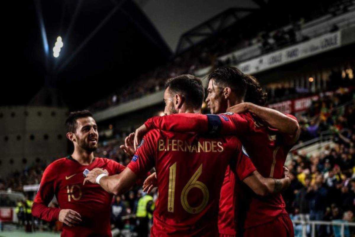 Portugal's forward Cristiano Ronaldo (R) celebrates with teammates after scoring during the Euro 2020 Group B football qualification match between Portugal and Lithuania at the Algarve stadium in Faro, on November 14, 2019. (Photo by PATRICIA DE MELO MOREIRA / AFP)
