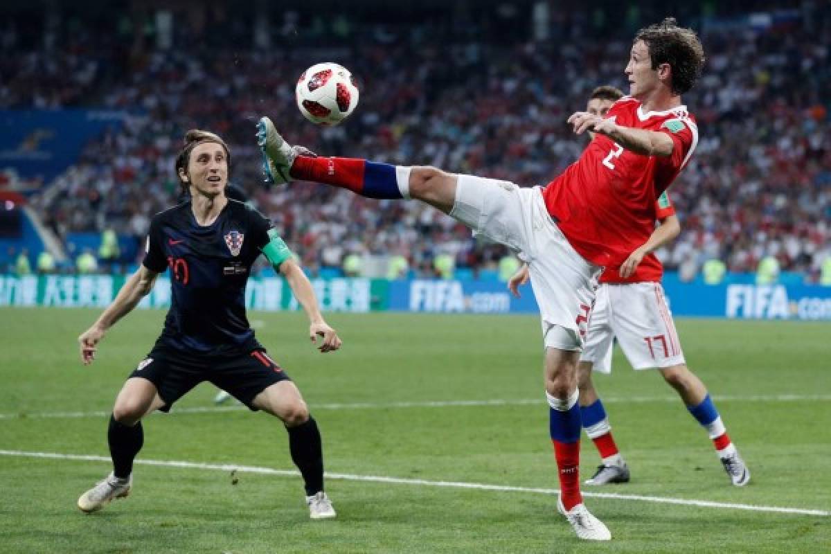 Russia's defender Mario Fernandes (R) controls the ball ahead of Croatia's midfielder Luka Modric during the Russia 2018 World Cup quarter-final football match between Russia and Croatia at the Fisht Stadium in Sochi on July 7, 2018. / AFP PHOTO / Adrian DENNIS / RESTRICTED TO EDITORIAL USE - NO MOBILE PUSH ALERTS/DOWNLOADS