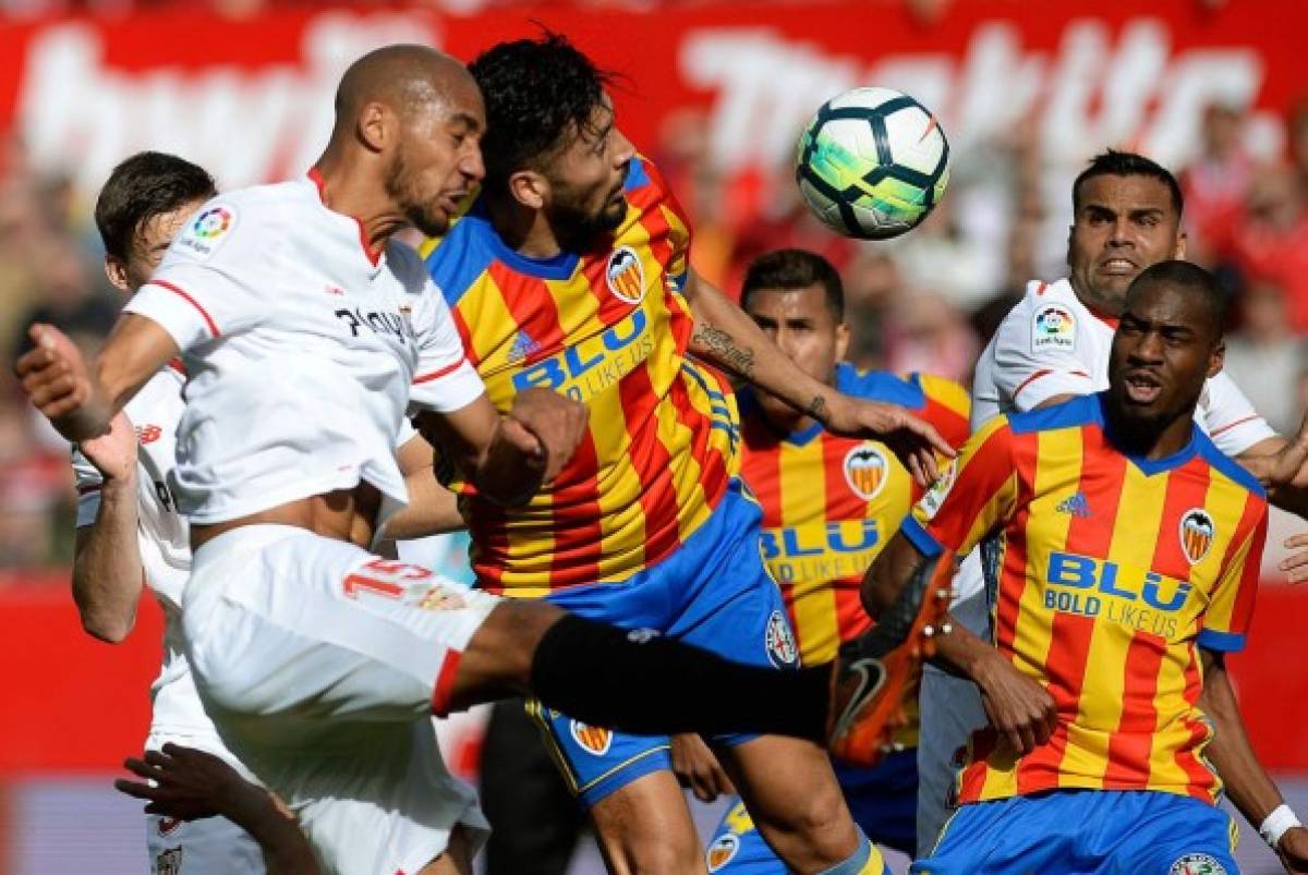 Sevilla's French midfielder Steven N'Zonzi (L) heads the ball with Valencia's Argentinian defender Ezequiel Garay (2ndL) during the Spanish league football match between Sevilla and Valencia at the Ramon Sanchez Pizjuan stadium in Sevilla on March 10, 2018. / AFP PHOTO / Cristina Quicler