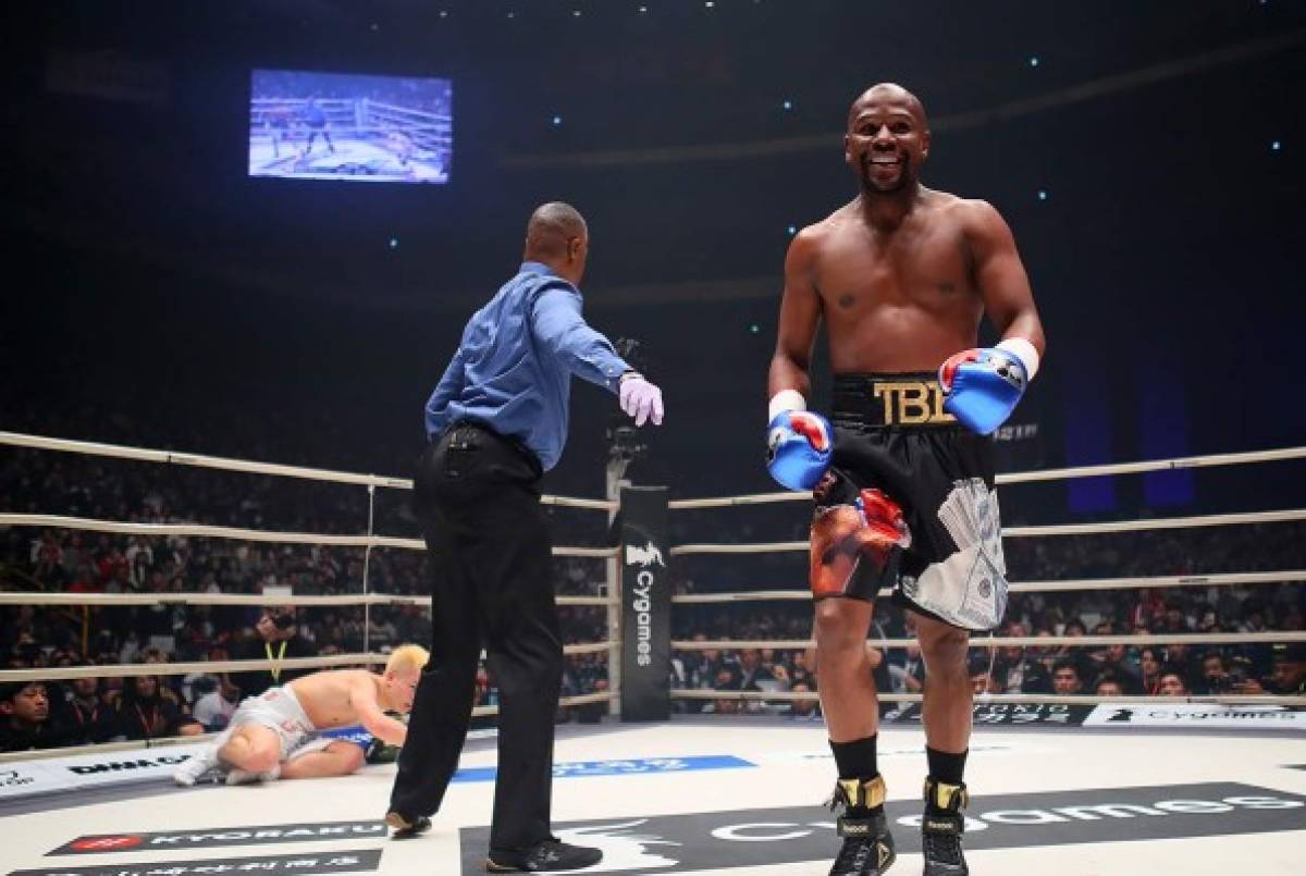 In this handout photograph taken on December 31, 2018 and released by Rizin Fighting Federation, US boxing legend Floyd Mayweather Jr (R) smiles after knocking down Kickboxer Tenshin Nasukawa of Japan (L) during their exhibition match at Saitama Super Arena in Saitama. - Floyd Mayweather beat Japanese kickboxing phenomenon Tenshin Nasukawa by a technical knock-out in the first round of a New Year's Eve 'exhibition' bout that brought the US boxing superstar out of retirement. (Photo by Handout / 2015 RIZIN FF / AFP) / ---EDITORS NOTE --- RESTRICTED TO EDITORIAL USE - MANDATORY CREDIT 'AFP PHOTO / 2015 RIZIN FF' - NO MARKETING - NO ADVERTISING CAMPAIGNS - DISTRIBUTED AS A SERVICE TO CLIENTS - NO ARCHIVES ---