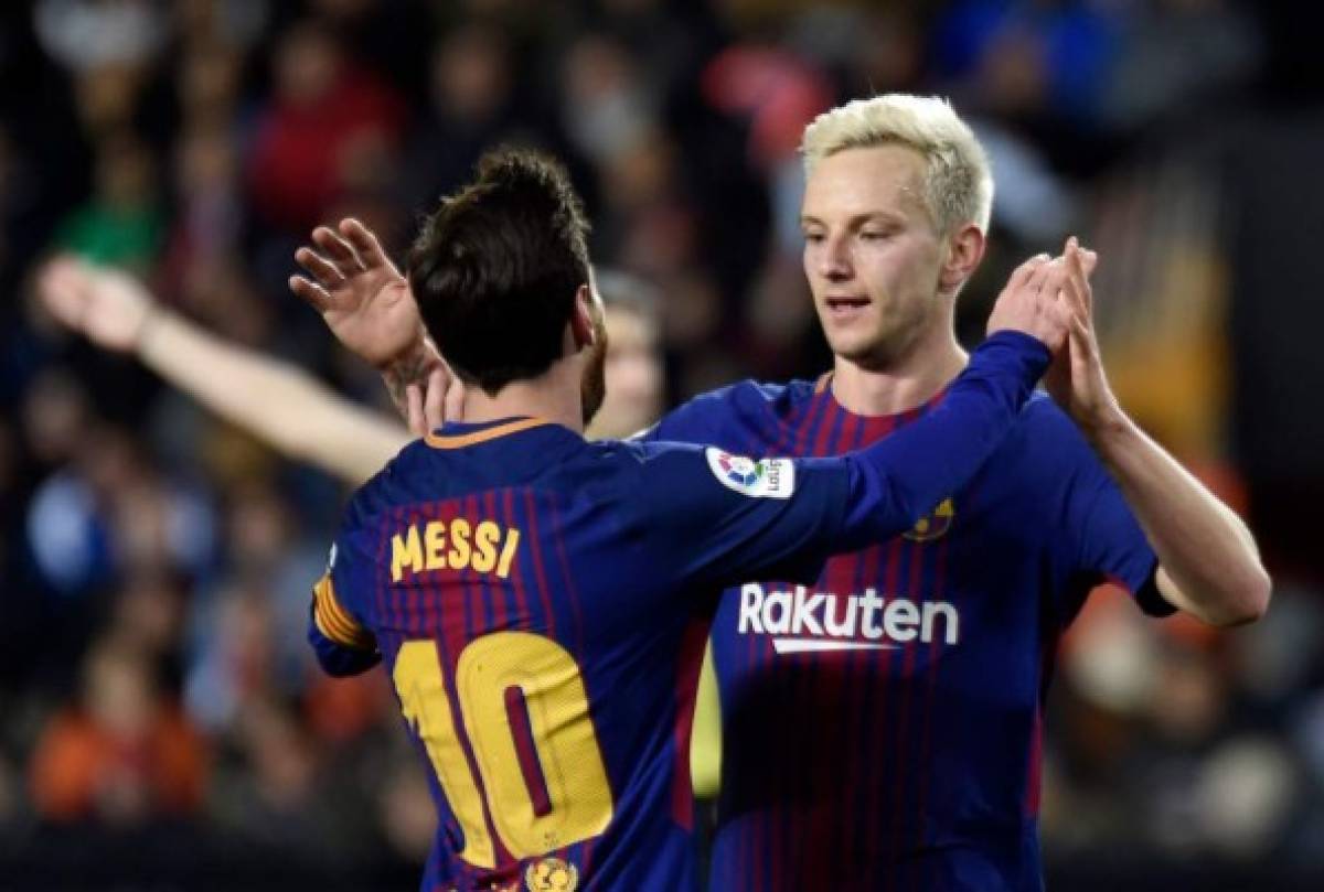 Barcelona's Croatian midfielder Ivan Rakitic (R) celebrates a goal with Barcelona's Argentinian forward Lionel Messi during the Spanish 'Copa del Rey' (King's cup) second leg semi-final football match between Valencia CF and FC Barcelona at the Mestalla stadium in Valencia on February 8, 2018. / AFP PHOTO / JOSE JORDAN