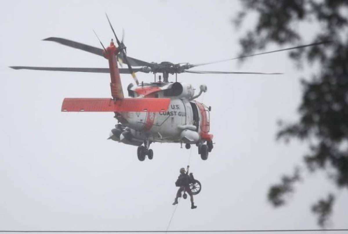 HOUSTON, TX - AUGUST 28: A Coast Guard helicopter hoists a wheel chair on board after lifting a person to safety from the area that was inundated with flooding from Hurricane Harvey on August 28, 2017 in Houston, Texas. Harvey, which made landfall north of Corpus Christi late Friday evening, is expected to dump upwards to 40 inches of rain in Texas over the next couple of days. Joe Raedle/Getty Images/AFP