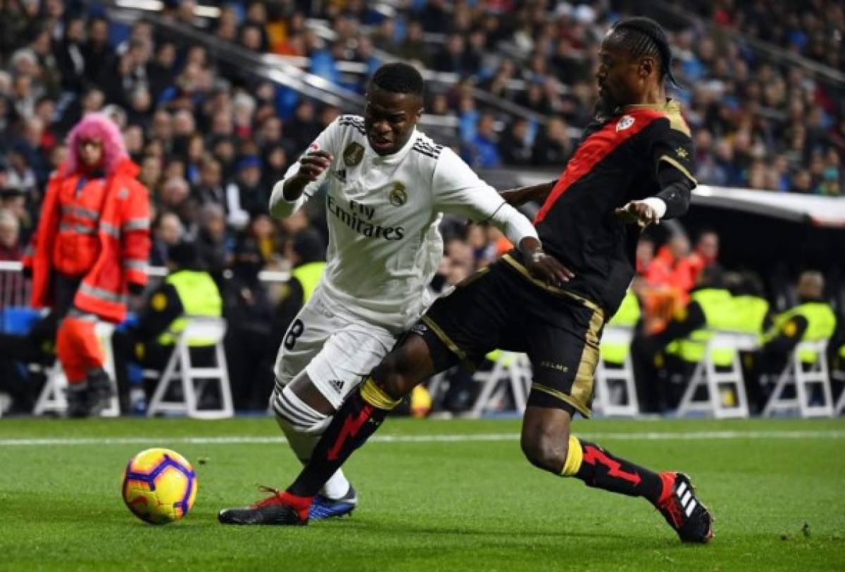 Real Madrid's Brazilian forward Vinicius Junior (L) vies with Rayo Vallecano's Senegalese defender Abdoulaye Ba during the Spanish League football match between Real Madrid and Rayo Vallecano at the Santiago Bernabeu stadium in Madrid on December 15, 2018. (Photo by GABRIEL BOUYS / AFP)