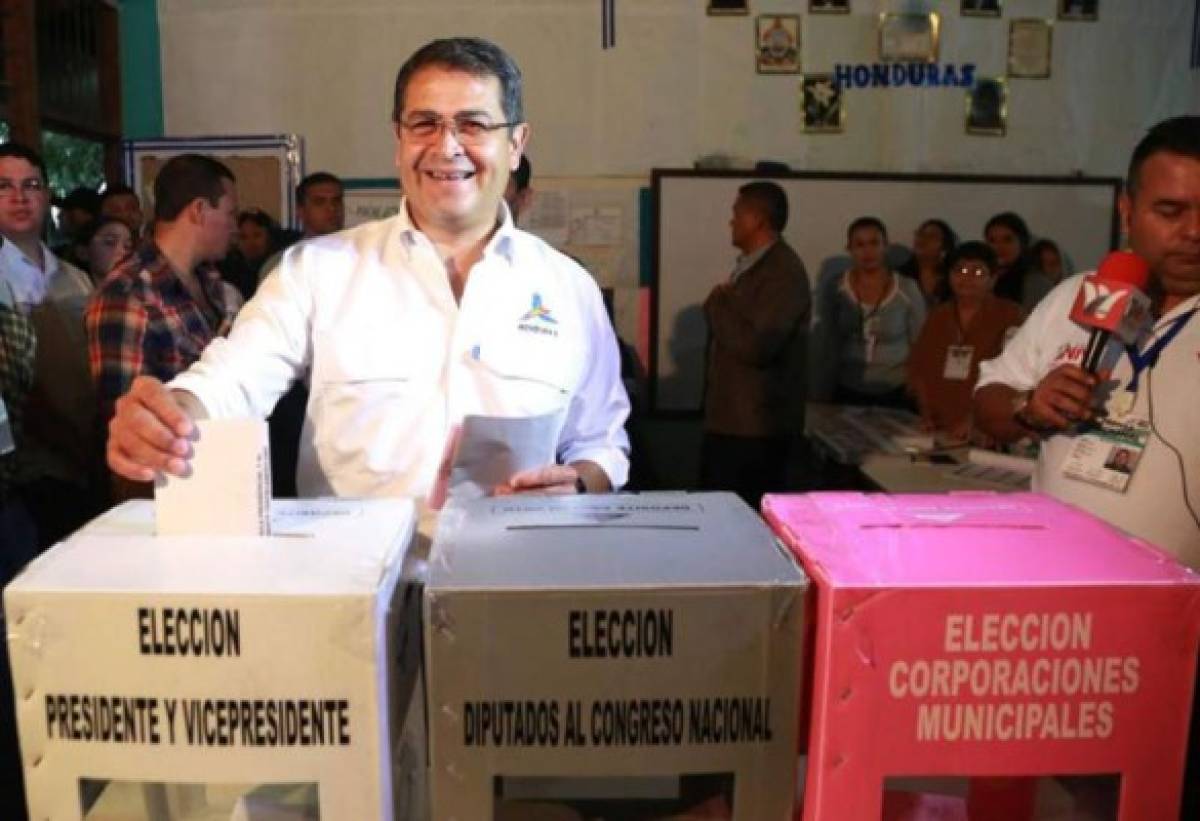 This handout picture released by Honduras' Presidency shows Honduran President Juan Orlando Hernandez, casting his ballot at a polling station in Gracias, Lempira department, 180 km from Tegucigalpa, during the general election on November 26, 2017. Honduras' six million voters are to cast ballots in a controversial election Sunday in which President Juan Orlando Hernandez is seeking a second mandate despite a constitutional one-term limit. This small country is at the heart of Central America's 'triangle of death,' an area plagued by gangs and poverty. / AFP PHOTO / Honduras' Presidency / HO / RESTRICTED TO EDITORIAL USE - MANDATORY CREDIT 'AFP PHOTO / Honduras' Presidency' - NO MARKETING NO ADVERTISING CAMPAIGNS - DISTRIBUTED AS A SERVICE TO CLIENTS / “The erroneous mention[s] appearing in the metadata of this photo by HO has been modified in AFP systems in the following manner: [in Gracias, Lempira department, 180 km from Tegucigalpa] instead of [Tegucigalpa]. Please immediately remove the erroneous mention[s] from all your online services and delete it (them) from your servers. If you have been authorized by AFP to distribute it (them) to third parties, please ensure that the same actions are carried out by them. Failure to promptly comply with these instructions will entail liability on your part for any continued or post notification usage. Therefore we thank you very much for all your attention and prompt action. We are sorry for the inconvenience this notification may cause and remain at your disposal for any further information you may require.”