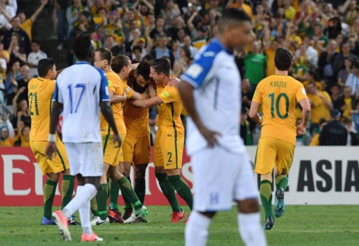 Australia's Mile Jedinak (C) is embraced by teammates as they celebrate their victory in their World Cup 2018 qualifying football match against Honduras in Sydney on November 15, 2017. / AFP PHOTO / Saeed KHAN / -- IMAGE RESTRICTED TO EDITORIAL USE - STRICTLY NO COMMERCIAL USE --