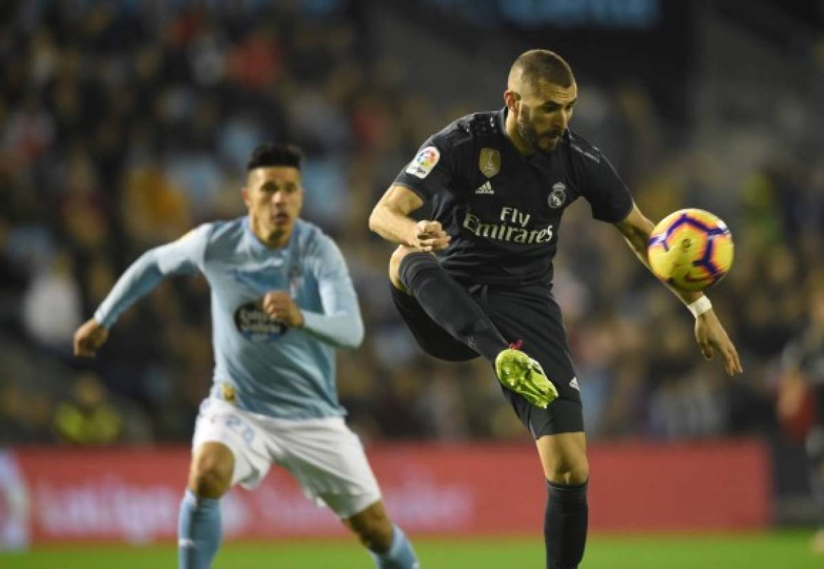 Real Madrid's French forward Karim Benzema (R) vies with Celta Vigo's Argentinian defender Facundo Roncaglia during the Spanish league football match between RC Celta de Vigo and Real Madrid CF at the Balaidos stadium in Vigo on November 11, 2018. (Photo by MIGUEL RIOPA / AFP)