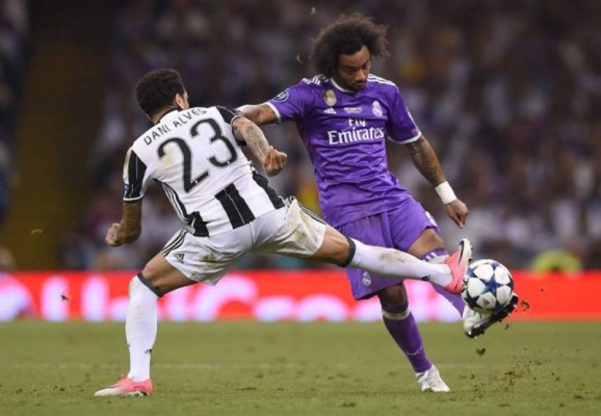 Juventus' Brazilian defender Dani Alves (L) blocks Real Madrid's Brazilian defender Marcelo during the UEFA Champions League final football match between Juventus and Real Madrid at The Principality Stadium in Cardiff, south Wales, on June 3, 2017. / AFP PHOTO / Filippo MONTEFORTE