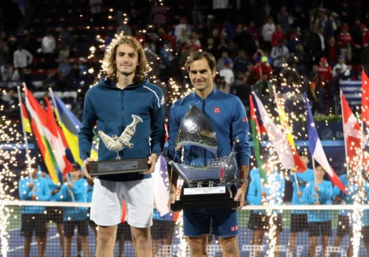 Switzerland's Roger Federer (R) poses with his trophy alongside Greece's Stefanos Tsitsipas after the final match at the ATP Dubai Tennis Championship in the Gulf emirate of Dubai on March 2, 2019. - Roger Federer won his 100th career title when he defeated Greece's Stefanos Tsitsipas 6-4, 6-4 in the final of the Dubai Championships. (Photo by KARIM SAHIB / AFP)