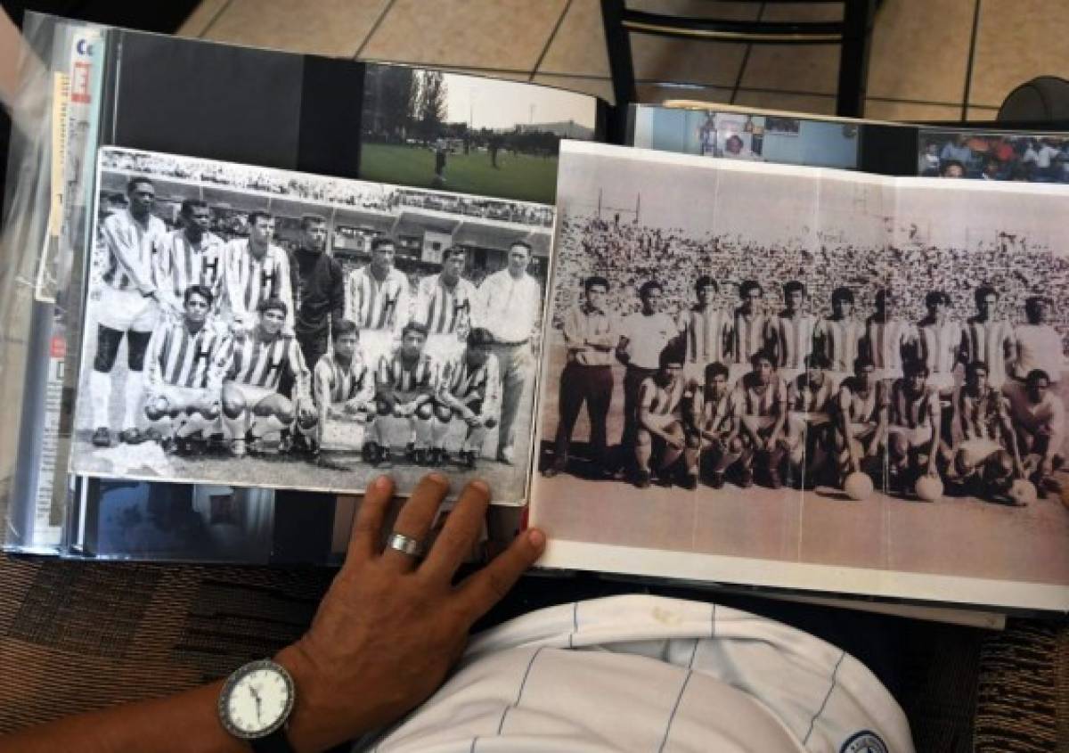 Honduran lawyer Marco Antonio 'Tonin' Mendoza, former capitan of the 1969 Honduran football team, shows pictures at his home in Tegucigalpa, on June 22, 2019. - 2019 commemorates 50th anniversary of the so-called 1969 'football war' between El Salvador and Honduras. (Photo by ORLANDO SIERRA / AFP)
