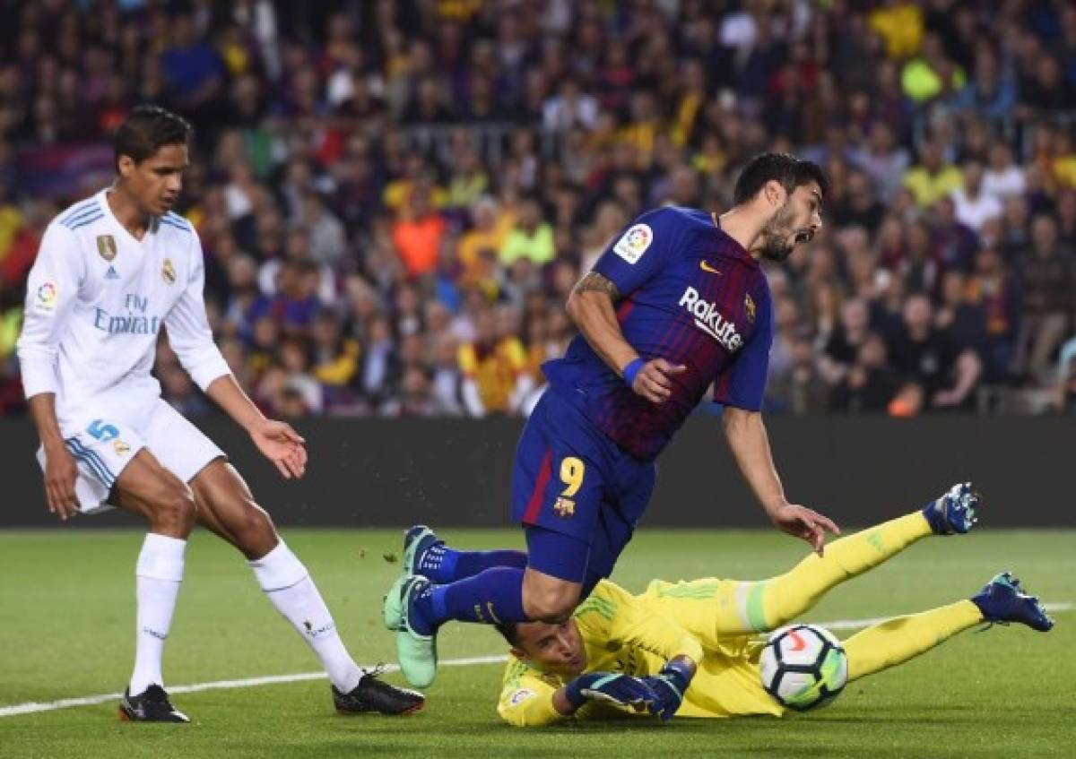 Barcelona's Uruguayan forward Luis Suarez (C) vies with Real Madrid's Costa Rican goalkeeper Keylor Navas (R) during the Spanish league football match between FC Barcelona and Real Madrid CF at the Camp Nou stadium in Barcelona on May 6, 2018. / AFP PHOTO / Josep LAGO